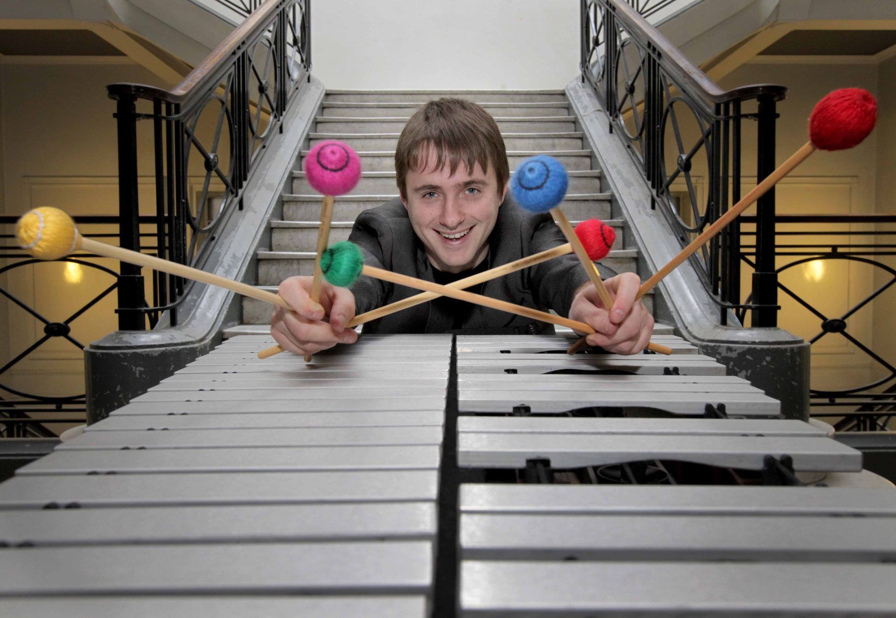 Alex Petcu holding brightly coloured mallets over a vibraphone
